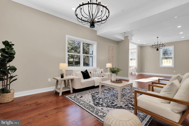 living area featuring baseboards, ornamental molding, dark wood finished floors, and an inviting chandelier