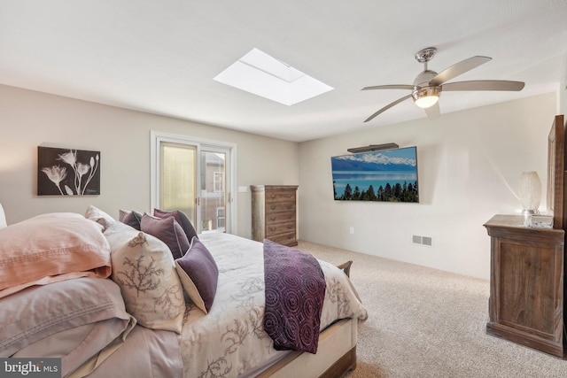 bedroom with ceiling fan, a skylight, and light colored carpet