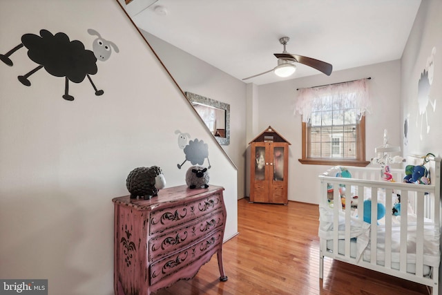 bedroom with hardwood / wood-style flooring and a crib