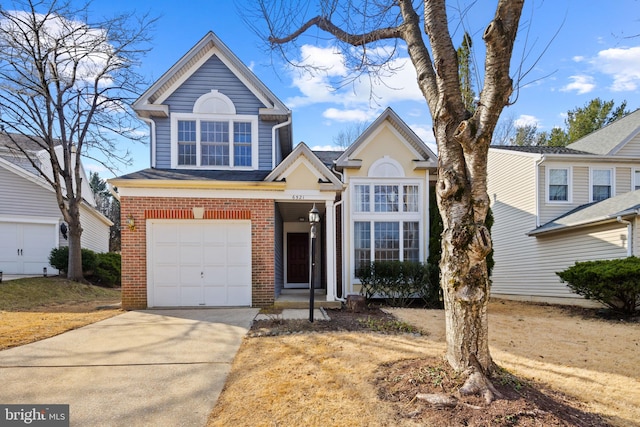 traditional home with concrete driveway, brick siding, and an attached garage