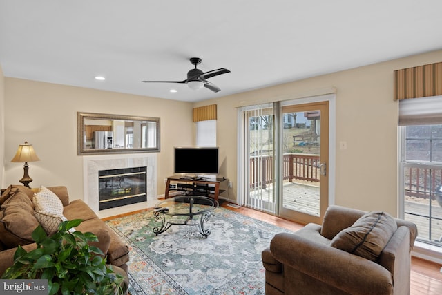 living area featuring ceiling fan, recessed lighting, a fireplace, and wood finished floors