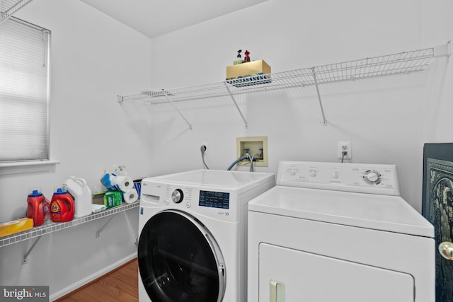 washroom featuring laundry area, separate washer and dryer, and wood finished floors