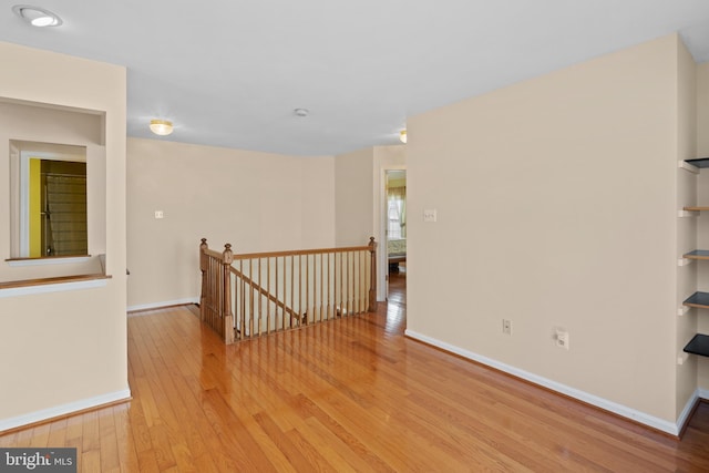 unfurnished room with wood-type flooring and baseboards