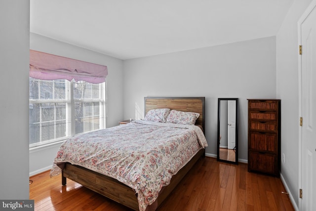 bedroom featuring wood-type flooring and baseboards