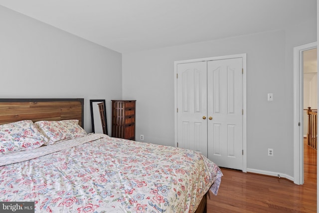 bedroom featuring a closet, baseboards, and wood finished floors