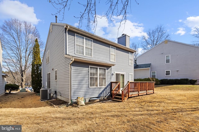 back of property featuring a deck, cooling unit, a yard, and a chimney