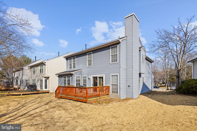 back of property with a chimney and a wooden deck