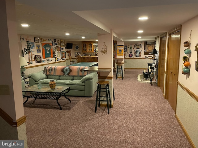 carpeted living area with a wainscoted wall, recessed lighting, baseboards, and wallpapered walls