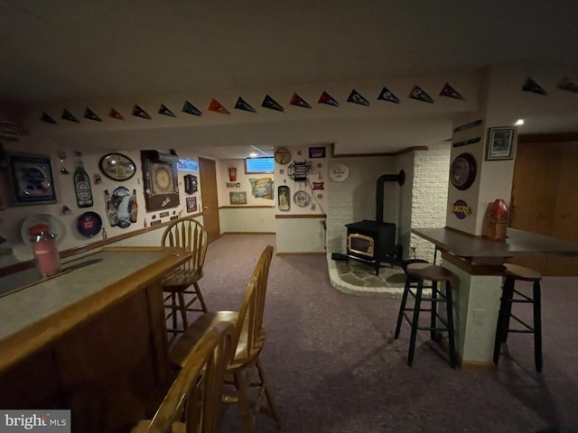 interior space with carpet floors, a bar, and a wood stove