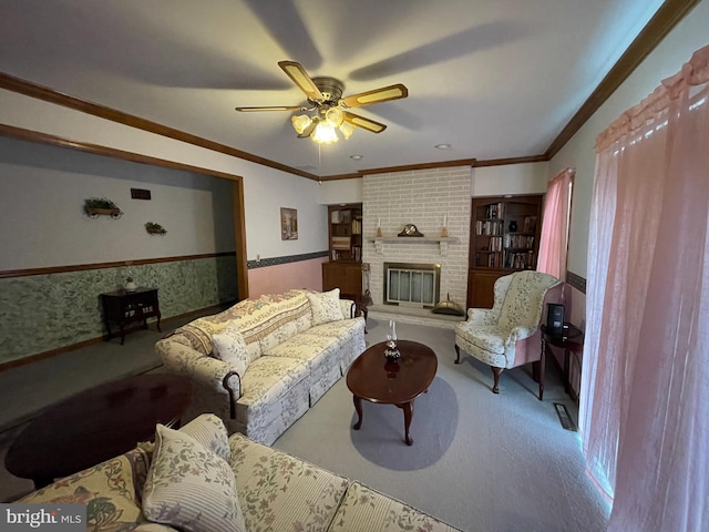 carpeted living room with ceiling fan, ornamental molding, a fireplace, and wallpapered walls