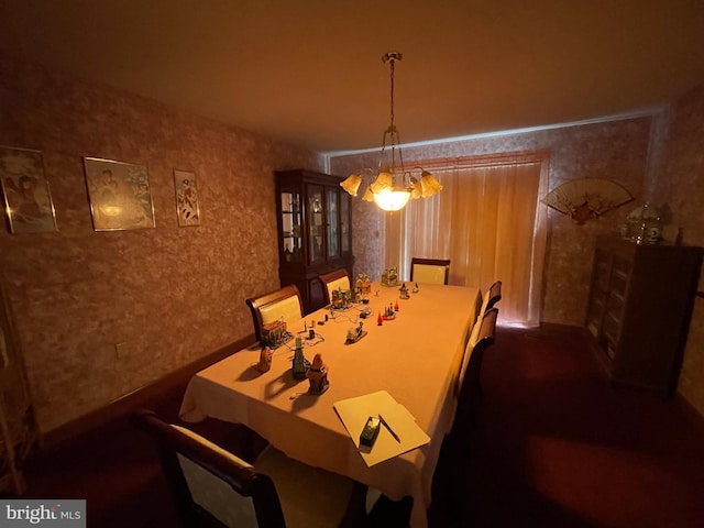 dining space with a chandelier and wallpapered walls