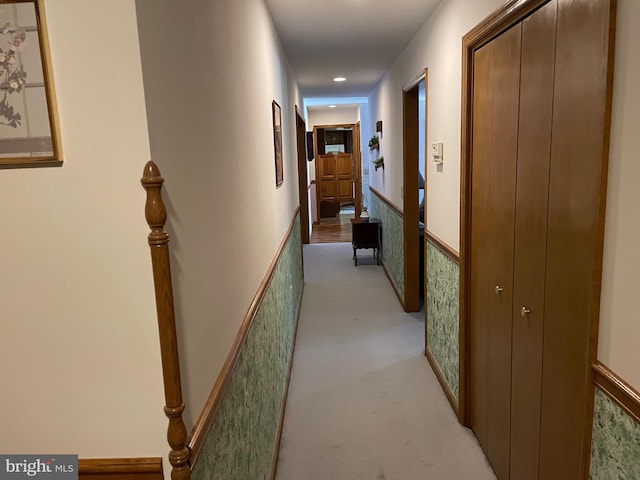 hallway featuring light colored carpet