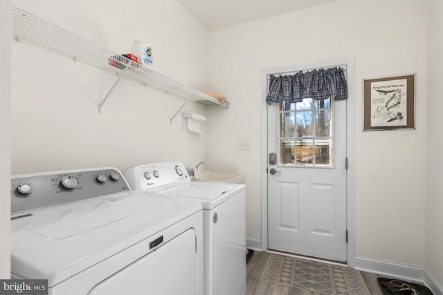 laundry room with hardwood / wood-style flooring, sink, and washer and dryer