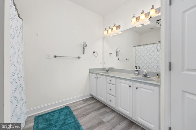 bathroom featuring wood-type flooring, a shower with shower curtain, and vanity