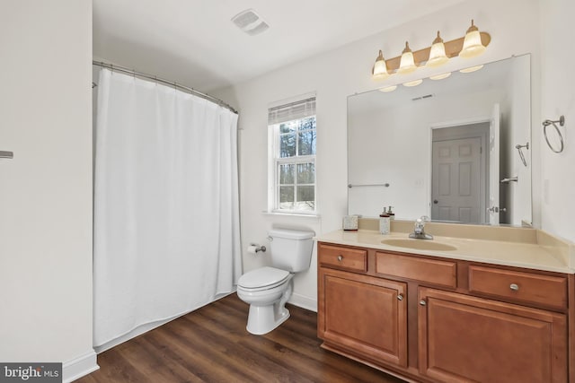 bathroom with wood-type flooring, vanity, and toilet