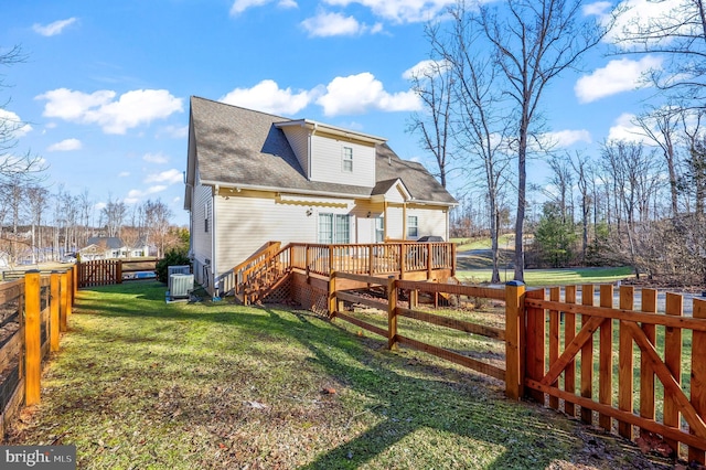 rear view of property featuring a yard, a deck, and central AC