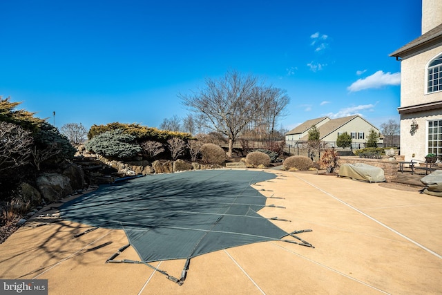 view of swimming pool featuring fence and a patio