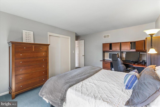 carpeted bedroom with baseboards, visible vents, a closet, and built in study area