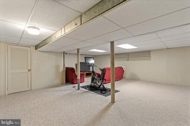 workout area featuring carpet floors and a paneled ceiling