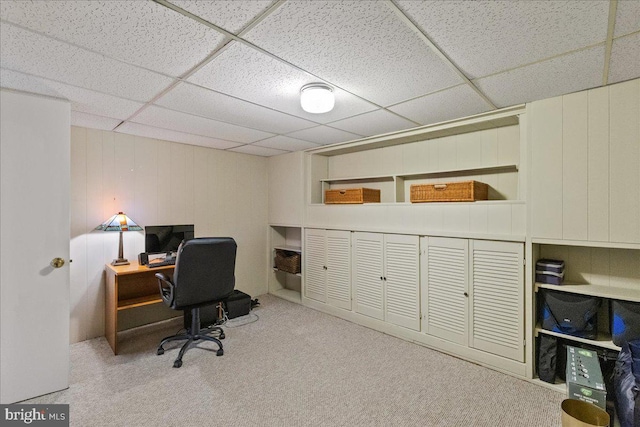 carpeted office with a paneled ceiling