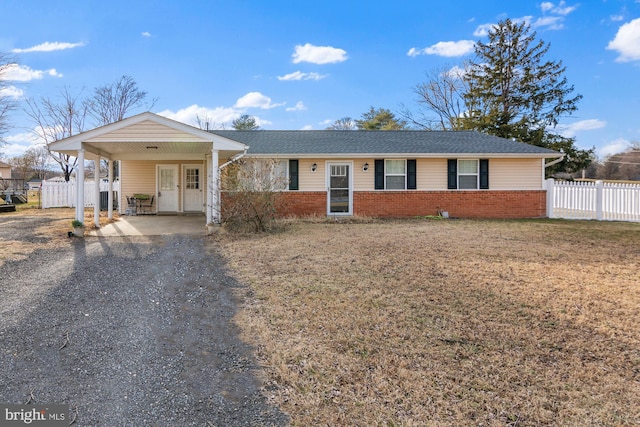 ranch-style house with brick siding, a carport, driveway, and fence