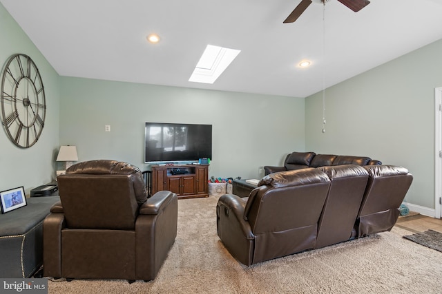 living area with a ceiling fan, recessed lighting, a skylight, baseboards, and light colored carpet