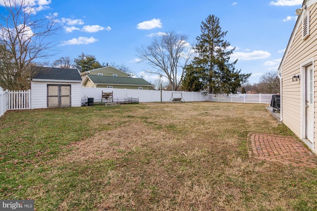 view of yard with an outbuilding, a fenced backyard, and a shed