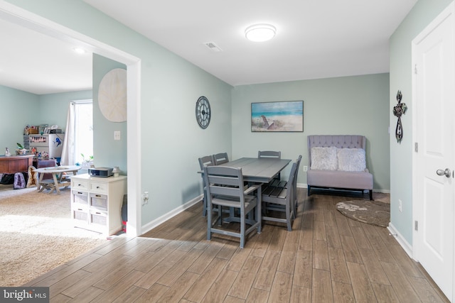 dining room featuring visible vents, baseboards, and wood finished floors