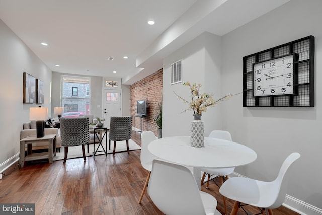 dining area featuring wood finished floors, visible vents, and baseboards