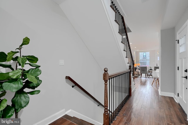 stairway with wood finished floors and baseboards