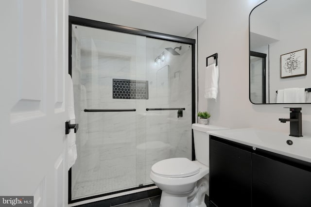 bathroom featuring toilet, a stall shower, and vanity