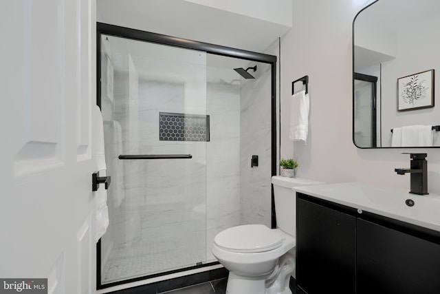 full bath featuring a stall shower, vanity, and toilet