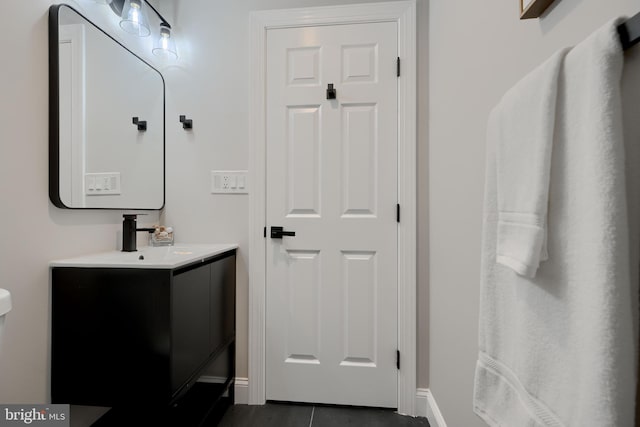 bathroom with tile patterned flooring, vanity, and baseboards