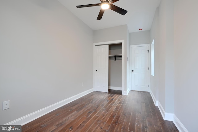 unfurnished bedroom featuring a closet, dark wood finished floors, a ceiling fan, and baseboards