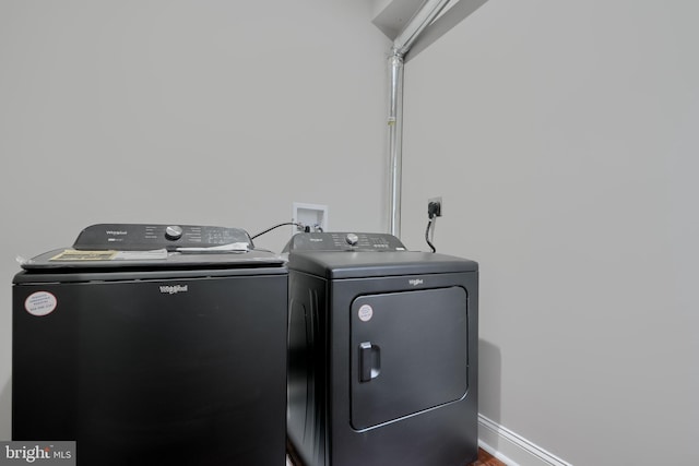 laundry room with laundry area, baseboards, and washer and dryer