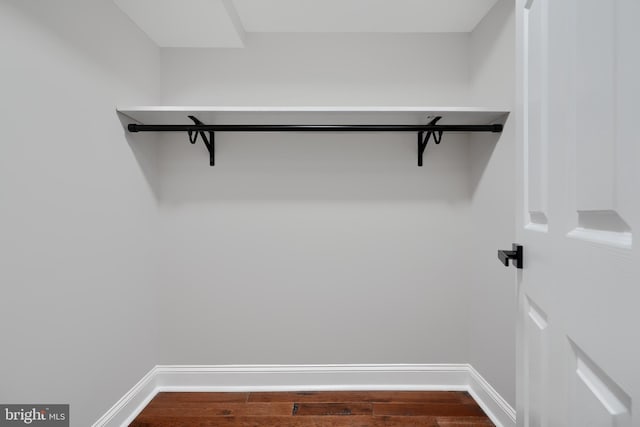 walk in closet with wood finished floors