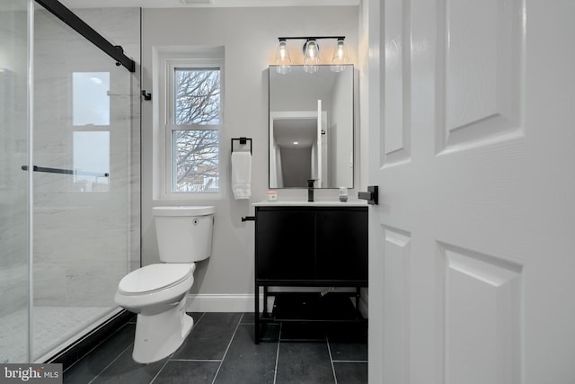 full bathroom featuring a stall shower, toilet, vanity, and baseboards