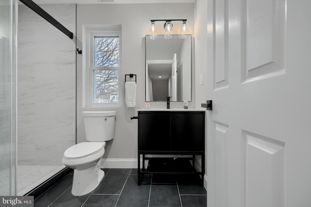 bathroom featuring tile patterned flooring, toilet, vanity, baseboards, and a shower stall