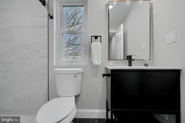 bathroom with toilet, baseboards, and vanity