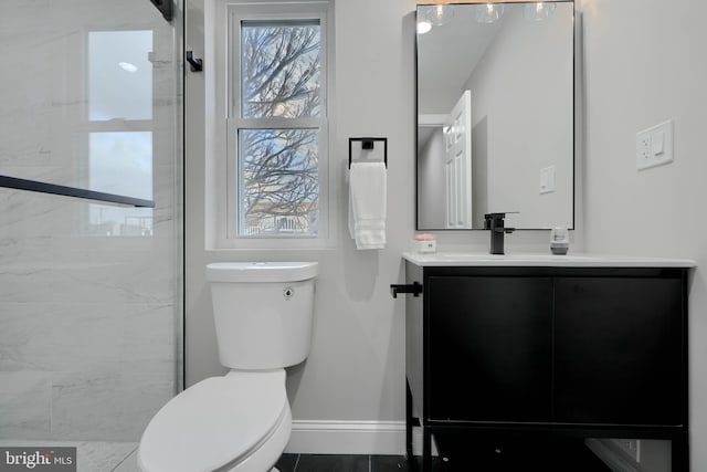 bathroom featuring toilet, baseboards, and vanity