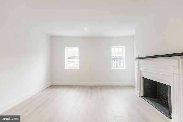 unfurnished living room featuring light hardwood / wood-style floors and a healthy amount of sunlight