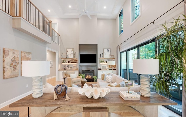 living room with light hardwood / wood-style flooring, a towering ceiling, coffered ceiling, and beamed ceiling