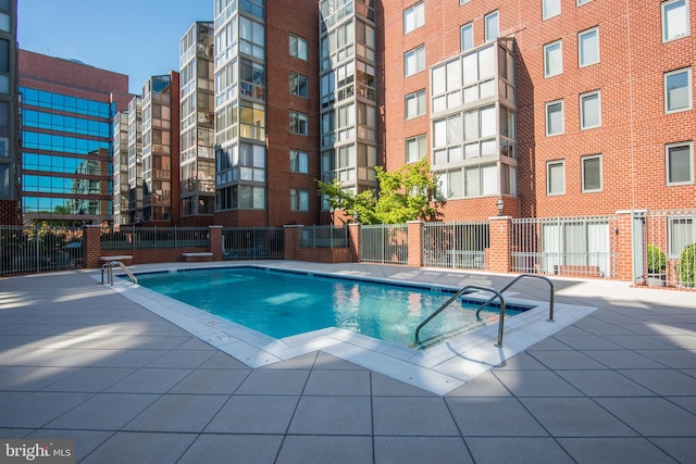 community pool with fence and a patio