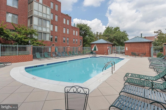 pool with fence and a patio