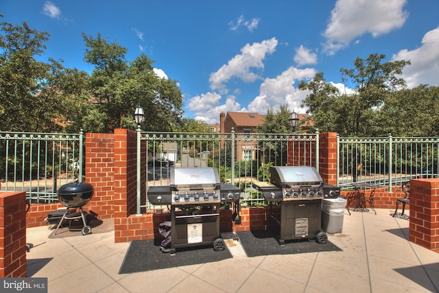 view of patio featuring a grill and fence