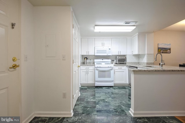 kitchen featuring light stone countertops, white appliances, white cabinets, and a sink