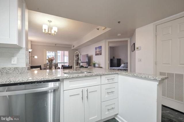 kitchen with dishwasher, a peninsula, open floor plan, and white cabinetry