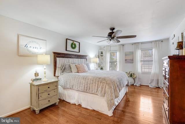 bedroom featuring a ceiling fan, baseboards, and wood finished floors