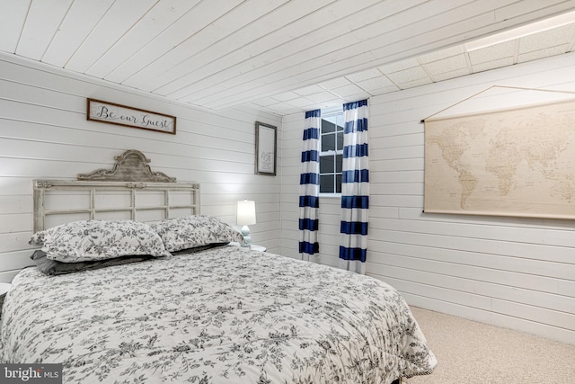 carpeted bedroom with wood walls and wood ceiling