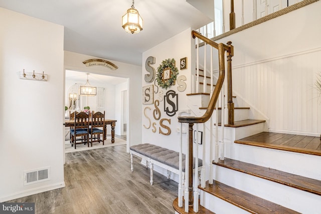 stairway featuring visible vents and wood finished floors